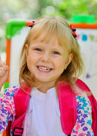 Little school girl with a backpack.