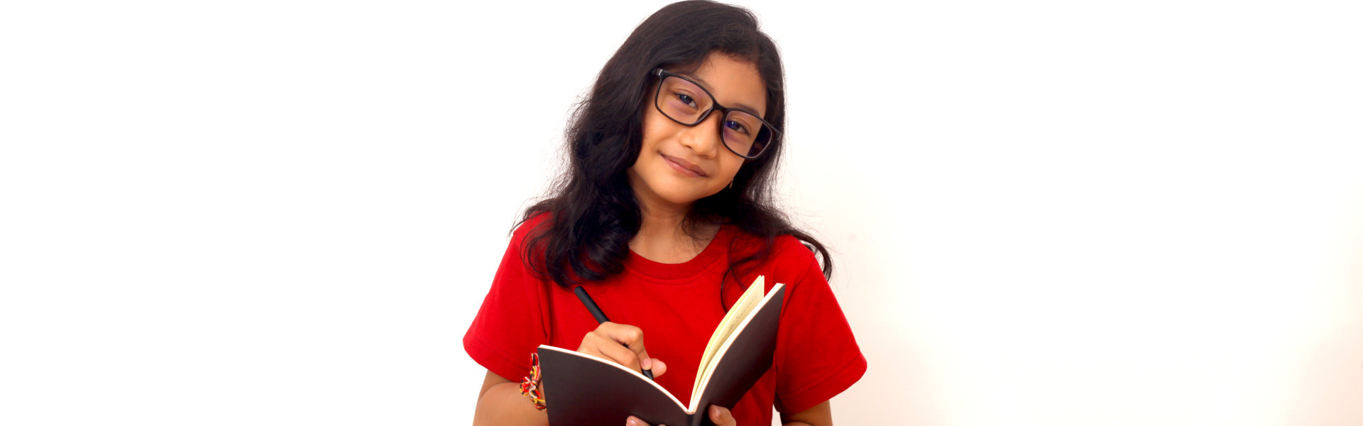elementary student standing while holding a book