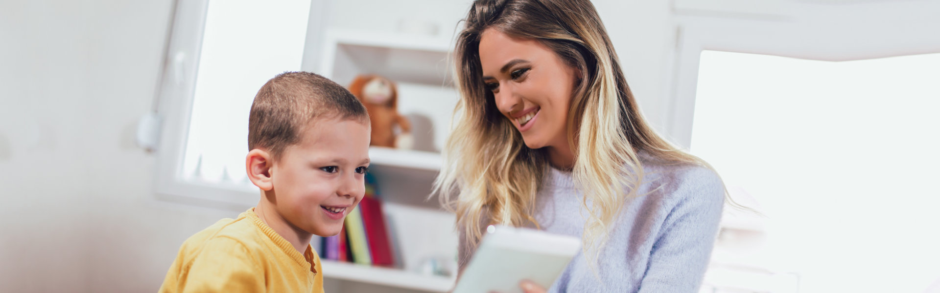 Young mother and her son play in kids room